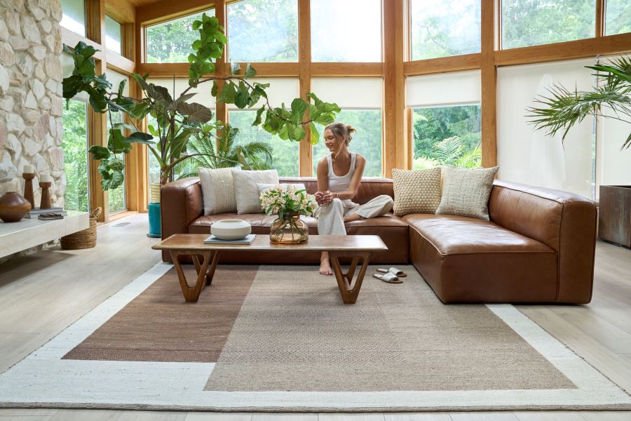Woman seated in a living room with a Scandinavian-inspired brown and beige rug